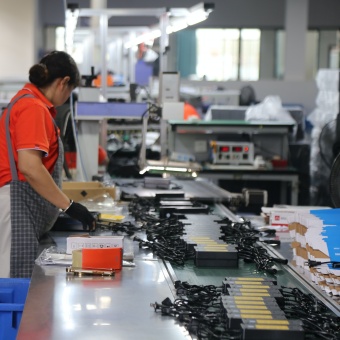 Battery charger bulk order packing with labels, accessories and cartons checked against shipment requirements.