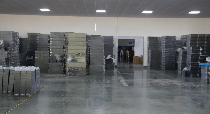 Molded battery charger housings stored in the factory production area
