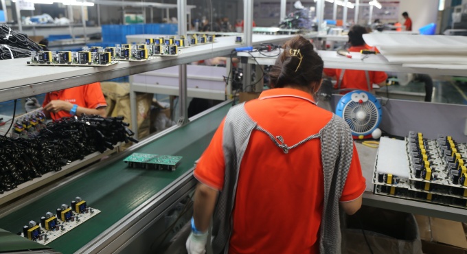 In-process inspection of battery charger PCBA boards at a factory quality control point
