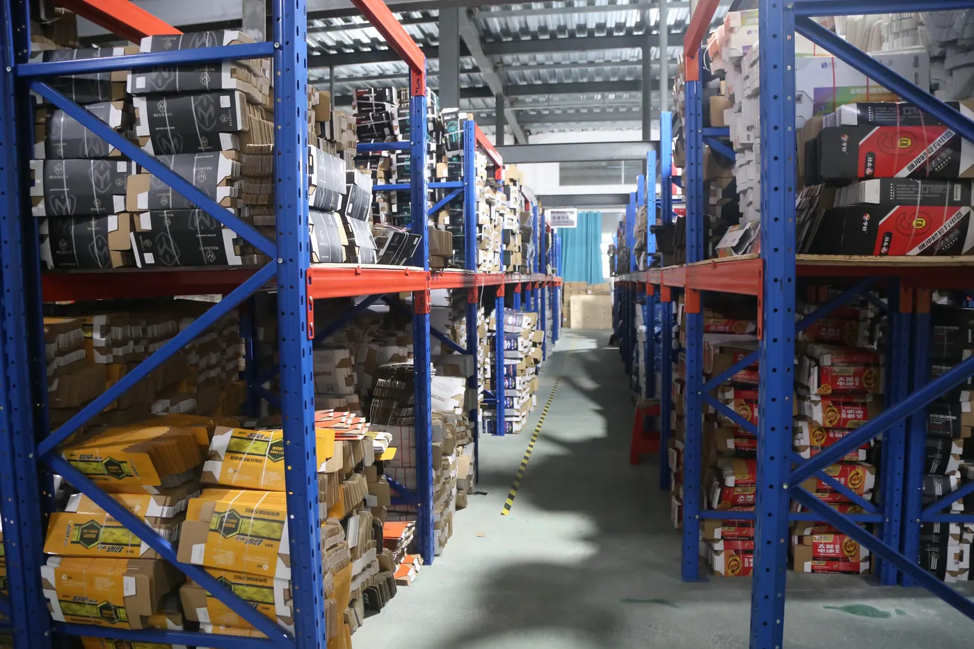 Rows of charger equipment and connected leads arranged on racks at the Linjia factory.