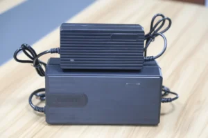 Two Linjia battery chargers with different housing designs and attached cables on a worktable.